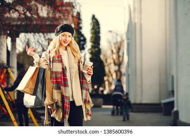 Elegant lady in a winter city. Stylish girl walking with shopping bags. Blonde in a cute beret - Shutterstock ID 1385600396