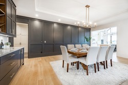 Elegant And Large Staged Dining Room With Dark Cabinets And Walls.