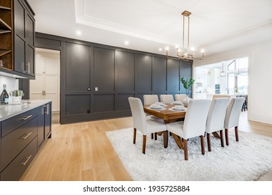 Elegant And Large Staged Dining Room With Dark Cabinets And Walls.