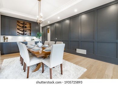 Elegant And Large Staged Dining Room With Dark Cabinets And Walls.