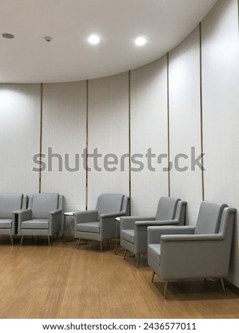 Elegant main lobby in hospital. Grey armchairs on wooden floor in a living room for decoration concept.
