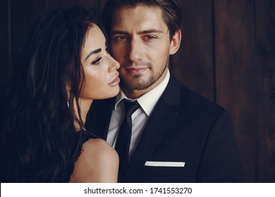 Elegant Man In A Black Suit. Couple At Home. Hot Woman In A Black Underwear