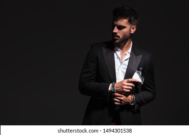 Elegant Man Fixing His Cufflinks And Looks Away To Side 