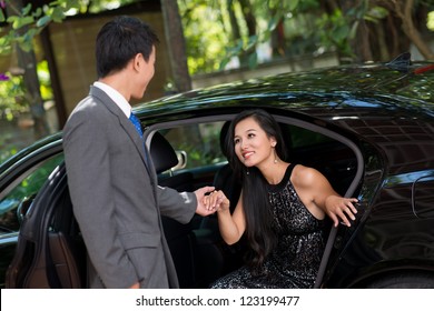 Elegant Man Helping His Wealthy Lady To Come Out Of The Car