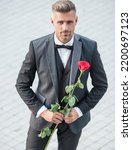 elegant man in tux. man wearing tux suit outside. handsome tux man with red rose
