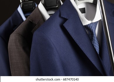 Elegant man's suits hanging in a row - closeup shot of classical man't suites