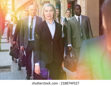 Elegant Mature Business Woman Walking On Modern City Street At Rush Hour.