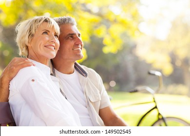 Elegant Mature Couple Sitting On A Bench Outdoors