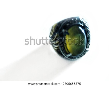 Elegant men's statement ring featuring a natural oval cut chrysoberyl cat's eye gemstone with a sharp chatoyancy effect. Set in a thick sterling silver band with intricate leaf carving details and surrounded by a halo of sparkling clear cubic zirconia stones. Isolated on a pure white background, perfect for jewelry catalog, e-commerce, fashion accessories, and men's luxury style concepts.