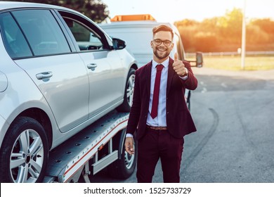 Elegant middle age business man is happy and satisfied with fast towing service for help on the road. He showing thumb up. Roadside assistance concept.