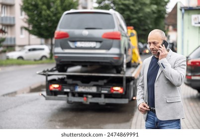 Elegant middle age business man calling insurance while towing service helping his on the road. Roadside assistance concept.
 - Powered by Shutterstock