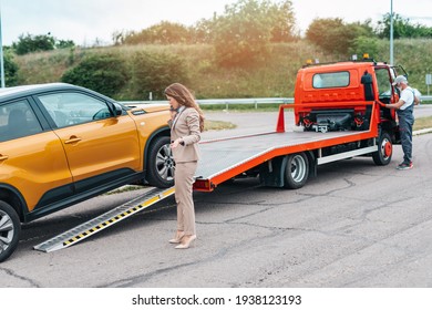 Elegant middle age business woman calling someone while towing service helping her on the road. Roadside assistance concept. - Powered by Shutterstock