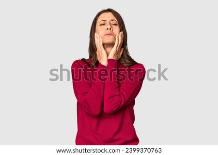 Elegant middle-aged Caucasian woman in studio setting whining and crying disconsolately.