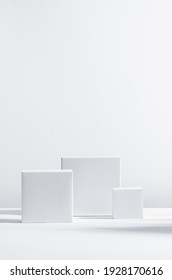 Style géométrique moderne et élégant de vitrine pour l'affichage des produits cosmétiques - podiums carrés blancs en lumière du soleil avec ombre sur fond blanc, verticale.