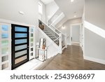 elegant and modern interior entry hallway foyer split level staircase and front door with glass panels and a table with items on entrance has side light windows home has dark hardwood steps flooring