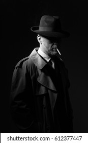 Elegant old fashioned man in the dark wearing a fedora hat and a trench coat, he is smoking a cigarette, 1950s noir movie style