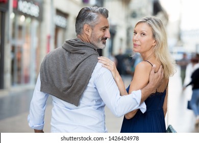 Elegant Older Couple Walking In City Street