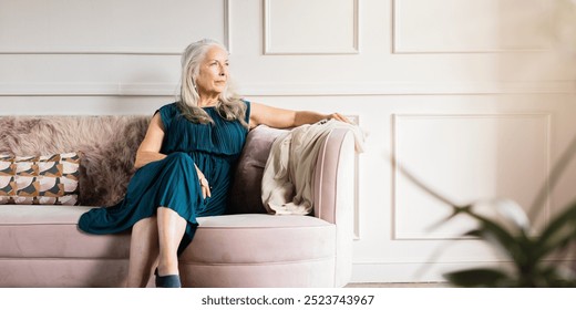 Elegant older woman wearing dress, sits on couch. The older woman looks thoughtful. Elegance old woman in luxury living room, calm old woman sitting thoughtful, elderly female in luxury vibes - Powered by Shutterstock