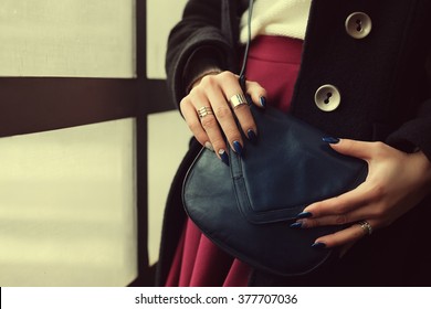 Elegant Outfit. Closeup Of Blue Leather Small Bag In Hands Of Stylish Woman. Fashionable Girl Near The Window. Female Fashion. Toned