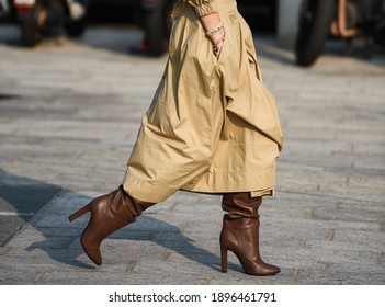 Elegant outfit in detail, women wearing cream coat and brown boots