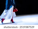 Elegant outfit, white long skirt, high heels and red handbag, fashion model walking on the catwalk