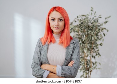 Elegant Pink-haired Woman Stands Against White Wall In Empty Room, Girl Has Arms Crossed Over Chest She Smiles At Camera Real Estate Agent Insurance Adjuster Corporate Office Worker Businesswoman