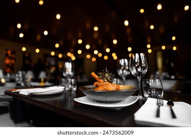 Elegant plated dish in a sophisticated restaurant setting with warm bokeh lighting in the background, highlighting the ambiance and fine dining experience. - Powered by Shutterstock