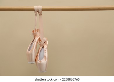 Elegantes puntas colgadas en ballet con fondo beige. Espacio para texto