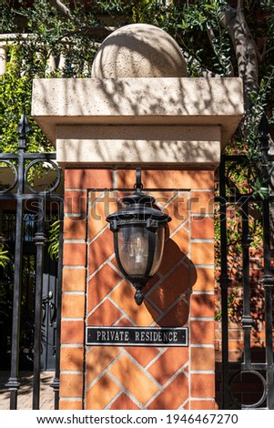 elegant post outside a private residence with sign, light, and herringbone red brick design