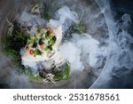 Elegant presentation of Crab with Caviar and herb, presented with liquid nitrogen smoke cascading over the plate. Luxury seafood dish at a fancy Restaurant.