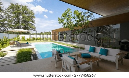Elegant private villa featuring a rectangular pool and a minimalist outdoor seating area under a wooden ceiling