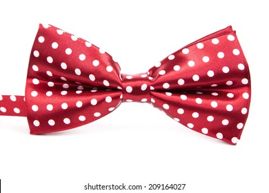 Elegant red bow tie with white polka dots on an isolated white background - Powered by Shutterstock