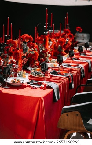 Elegant red table setting adorned with flowers for a festive gathering in a stylish venue