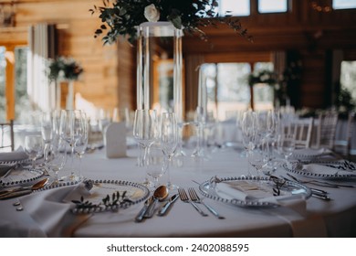 Elegant, romantic table setting for indoor wedding reception. Luxury wedding table decoration, special event table set up with fresh flowers arragements on high stands.