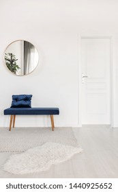 Elegant Round Mirror Above Velvet Bench In White Waiting Room Interior