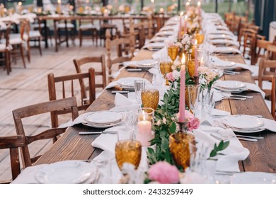 Elegant and rustic white and pink decor for a wedding dinner at restaurant in Italy, Tuscany. The tables are decorated with pink and white flowers and pink candles. Tables without people  - Powered by Shutterstock