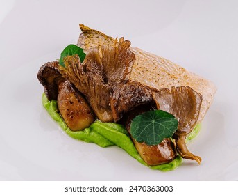 Elegant serving of seared fish over green pea puree with roasted mushrooms on a white plate - Powered by Shutterstock