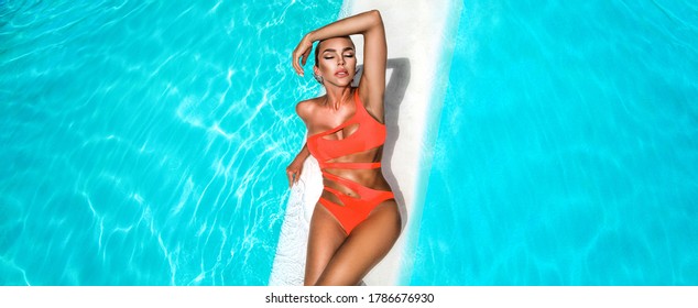 Elegant sexy woman in the orange bikini on the sun-tanned slim and shapely body is posing near the swimming pool - Image