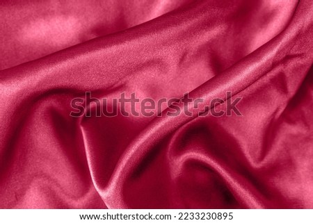 Elegant smooth satin folds closeup viva magenta colored. Cloth texture background. Abstract wallpaper. Trendy dark skyblue backdrop for web design. Luxury twisted fabric backplate