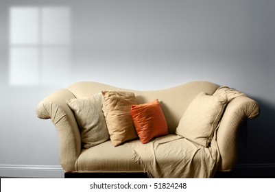 Elegant Sofa With Pillows Against Bare White Wall