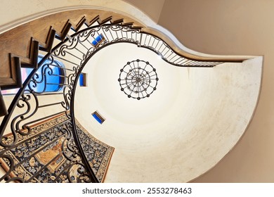 Elegant spiral staircase with intricate railing and chandelier - Powered by Shutterstock