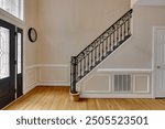 Elegant Staircase With Ornate Railing In A Brightly Lit Entryway Area