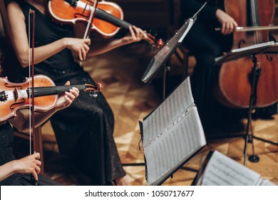Elegant String Quartet Playing In Luxury Room At Wedding Reception In Restaurant. Group Of People In Black Performing On Violin And Cello At Theatre Orchestra, Music Concept