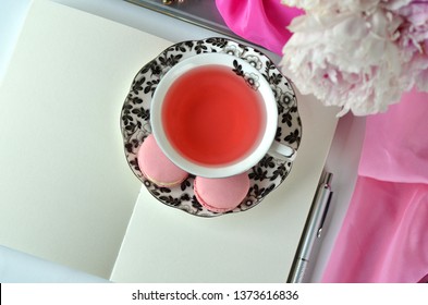 Elegant styled feminine desktop - relaxation, reading, creative writing, learning and journaling concept - with pink peonies, fruit tea and stylish stationery - Powered by Shutterstock