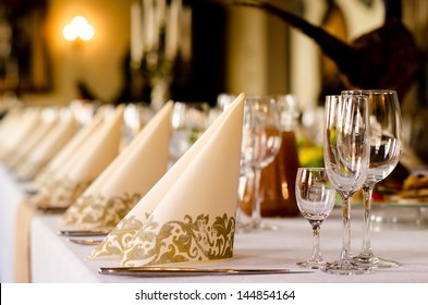 Elegant table set for a catered function with a low angle shallow depth of field view of the linen and glassware