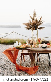 Elegant table set up in orange, red and gold for beautiful wedding reception on island