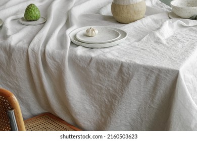 Elegant table setting with cherimoya fruits, garlic in craft ceramic plate on linen tablecloth. Outdoor table setting for summer holiday concept.