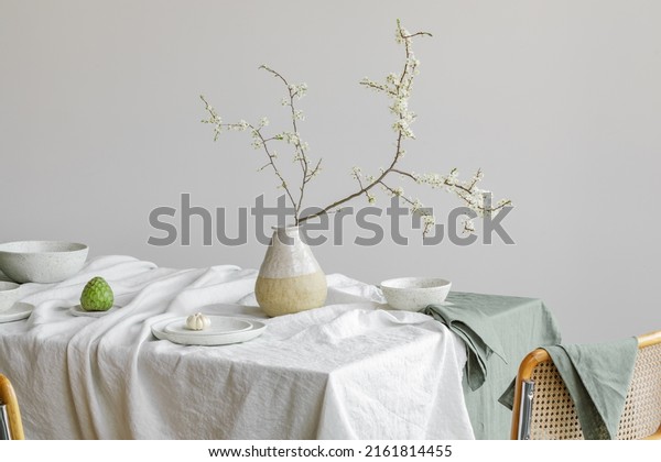 Elegant table setting\
with cherry brunch in craft vase , cherimoya fruits, garlic in\
craft ceramic plate on linen tablecloth. Outdoor table setting for\
summer holiday concept.