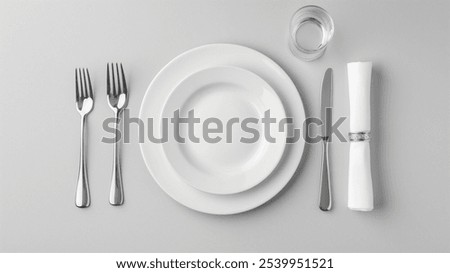 An elegant table setting with pristine white plates, silverware, a neatly folded napkin, and a glass of water, ideal for formal dining. Top View