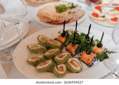 Elegant table setting with a variety of appetizers, including sushi rolls and meat platters, arranged on a white tablecloth, featuring wine glasses and a refined dining ambiance. - Powered by Shutterstock - Get 15% off with code: PIKWIZARD15